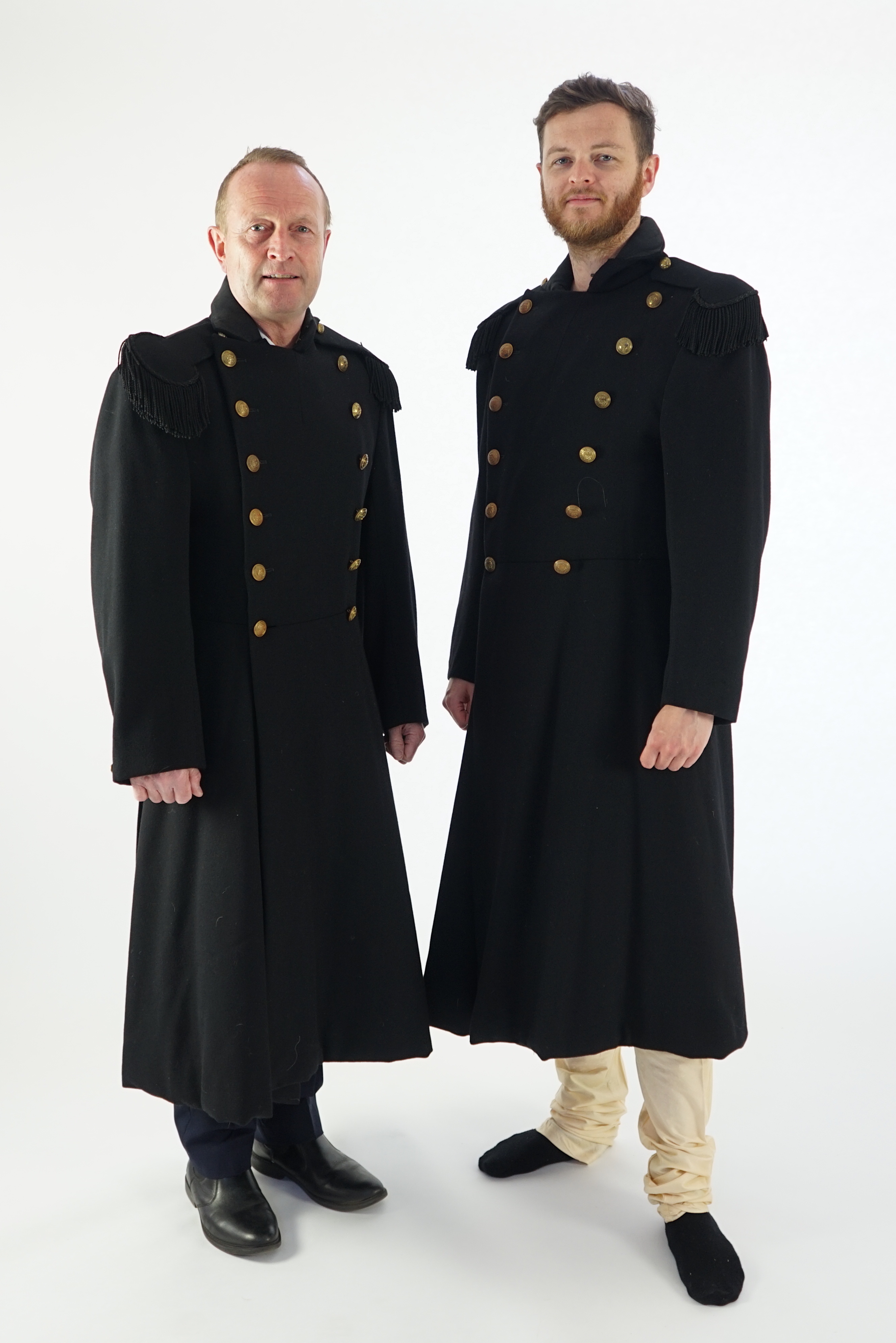 Two black military great coats with epaulettes and buttons. Ex Royal Opera House 'Tosca'